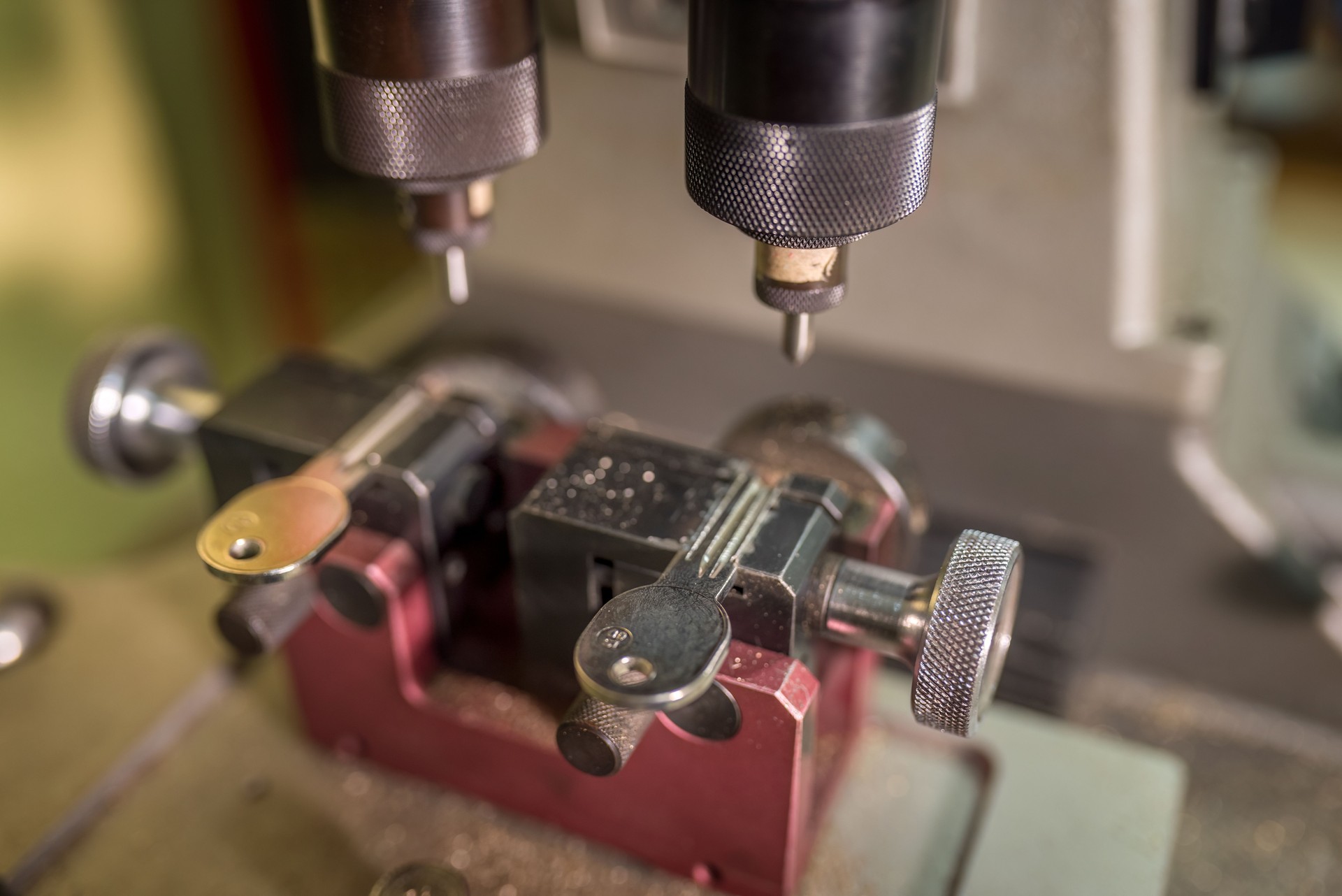 Key cutting machine duplicating key precisely, tracing original key's distinctive grooves and teeth with mechanical accuracy, ensuring faithful replication